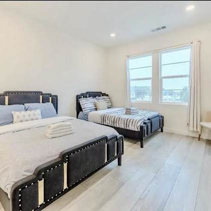 a bedroom with two beds and a chair.