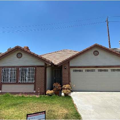a house with a garage and a sign in front of it.