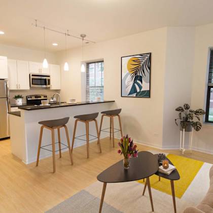 a modern kitchen with a bar and stools.