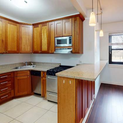 a kitchen with wooden cabinets and a stainless steel refrigerator.