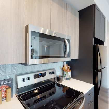 a modern kitchen with a black stove top oven and a black refrigerator.