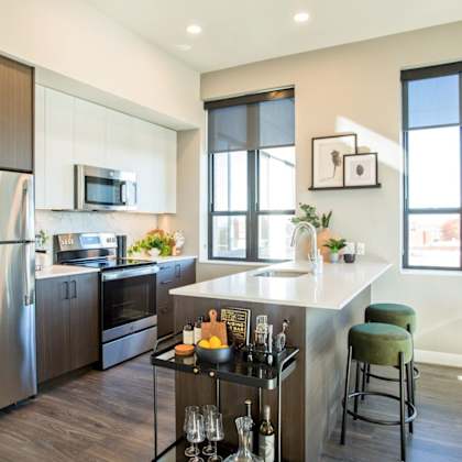 a modern kitchen with a stainless steel refrigerator and a bar area.