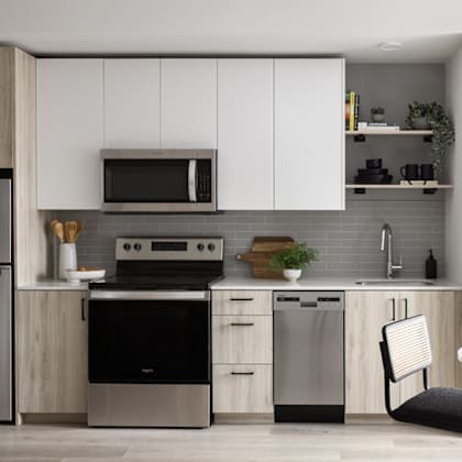 a modern kitchen with a refrigerator, oven, and microwave.