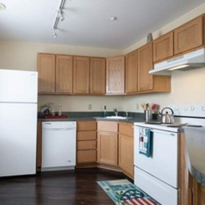 a kitchen with white appliances and wooden cabinets.