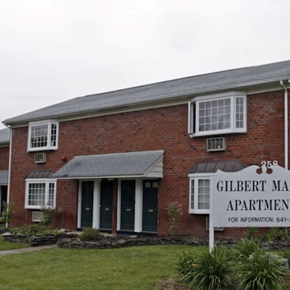 a brick building with a sign that says gilbert manor apartments.