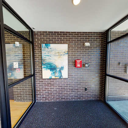 a hallway with a brick wall and a painting on it.