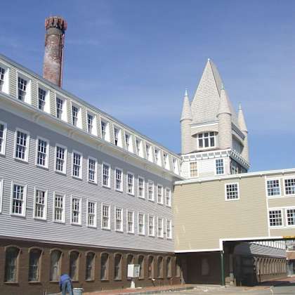 a building with a tall tower and a chimney.