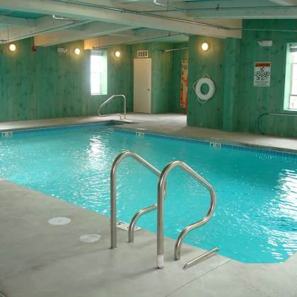 a large indoor swimming pool with a ladder on the side.
