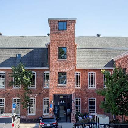 a red brick building with a black door and a black fence.