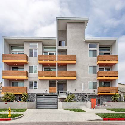 a modern apartment building with a mix of wood and concrete exterior.