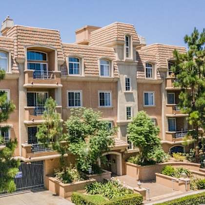 a large, multi-story residential building with a balcony on the second floor.