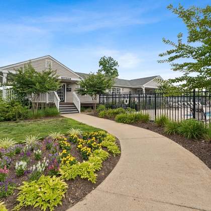 a sidewalk in front of a house with a pool at hyde park townhomes, prg real estate management, chester, va