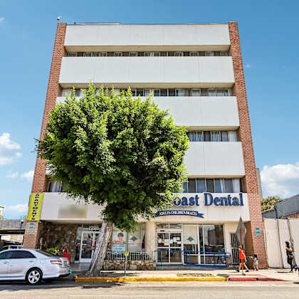 a white building with a sign that says "coast dental" on it.