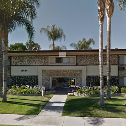 a building with palm trees in front of it.