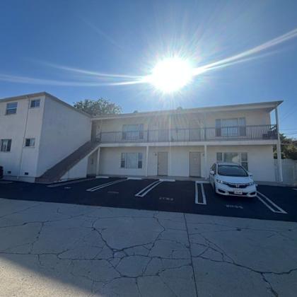a white building with a car parked in front of it.