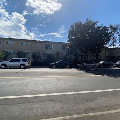 a parking lot with cars and a building in the background.