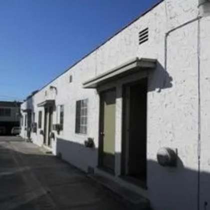 a white building with a green door and windows.