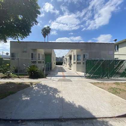 a sunny day at a residential area with a pathway leading to a building.