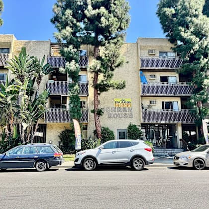 a row of cars parked in front of a building with a sign that says "house".