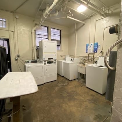 a room with white appliances and a concrete floor.
