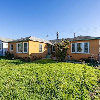 two houses with a green lawn in front.