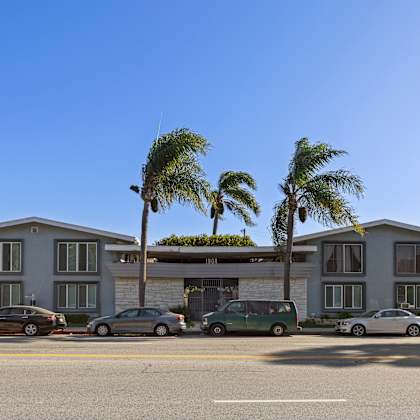 a row of houses with cars parked in front.
