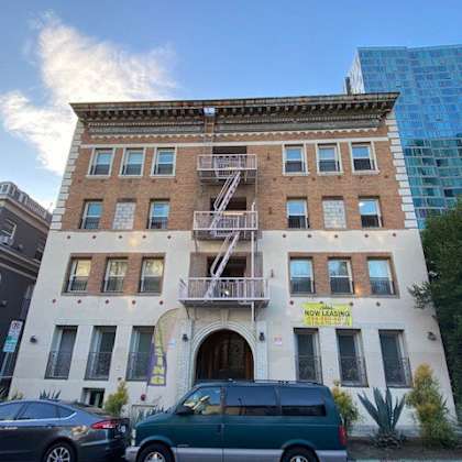 a building with a sign that says "no leasing" is in front of a blue building.