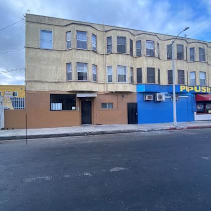 a building with a blue sign that says "popusria" on it.