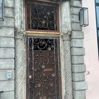 a wrought iron door with a glass window above it.