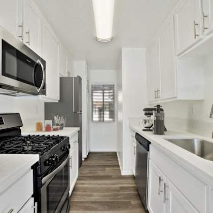 a kitchen with a sink and a stove and a microwave