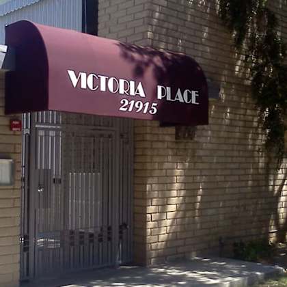 a building with a red awning that says "victoria place 21915".
