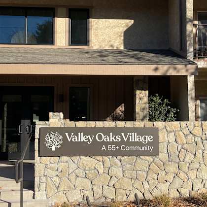 a sign that says valley oaks village in front of a building.