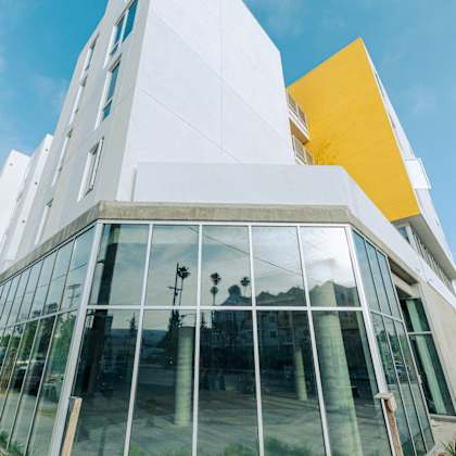 a modern building with a yellow accent and glass windows.