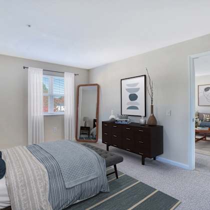 a bedroom with a bed and a dresser and a mirror