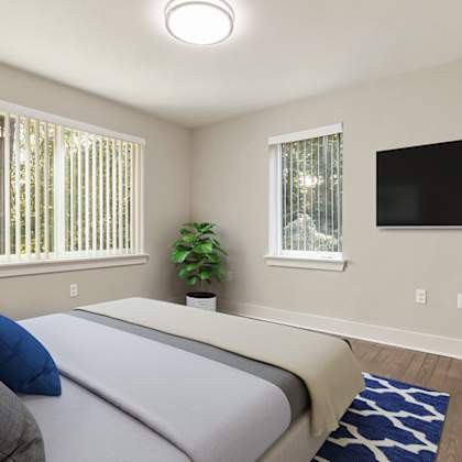 a bedroom with a bed, a plant, and a television.