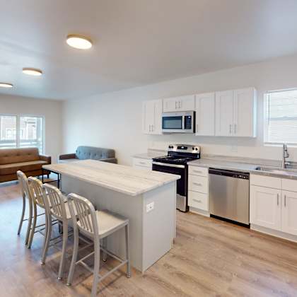 a kitchen with white cabinets and a wooden floor.