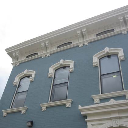 the side of a blue building with three windows