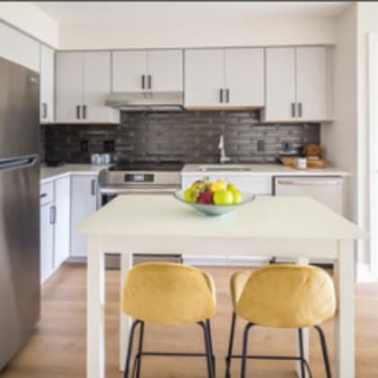 a kitchen with a table and chairs and a refrigerator.