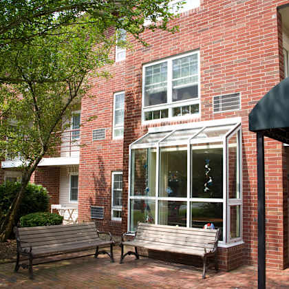 two benches in front of a brick building with a window