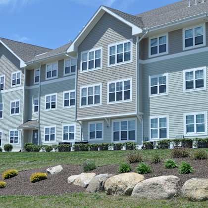 a large apartment building with large rocks in front of it
