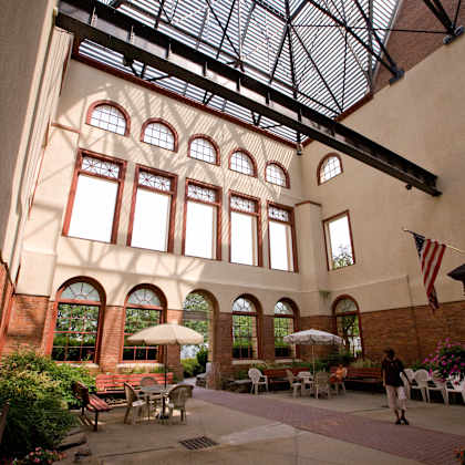 a large building with a glass ceiling and a courtyard with tables and chairs