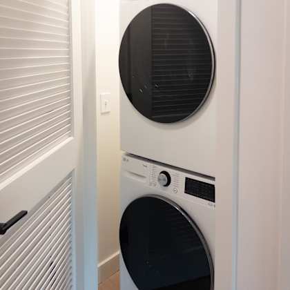 a white front loading washing machine in a laundry room.