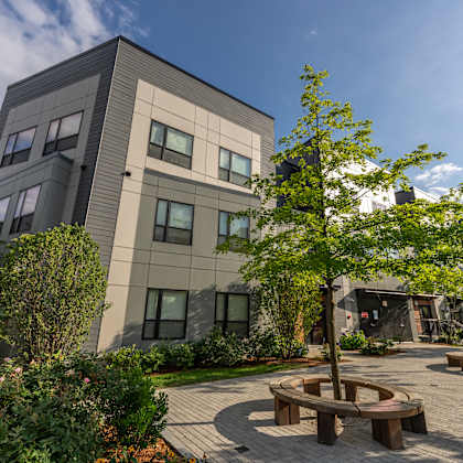 a courtyard with benches and trees in front of a building