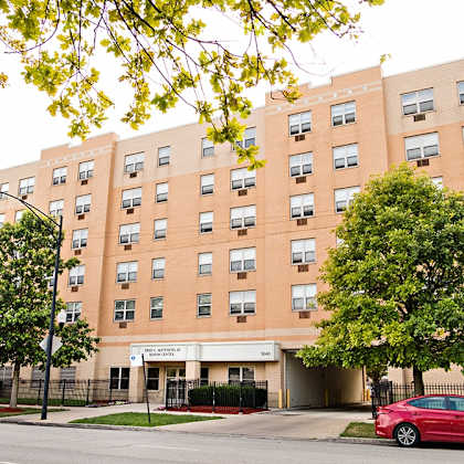a red car parked in front of an apartment building