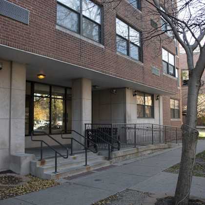 a brick building with stairs and a tree in front of it