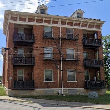 a red brick apartment building on the side of a street