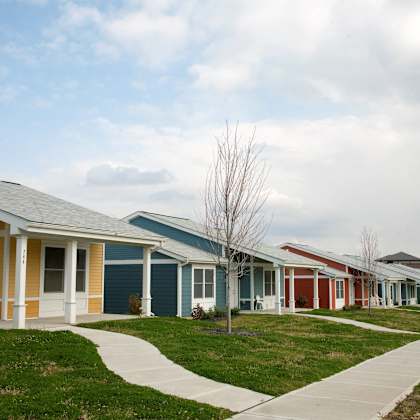 a row of houses in a neighborhood with grass and a sidewalk