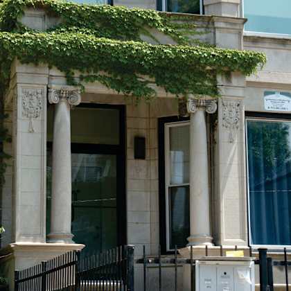 a building with a black iron fence in front of it.
