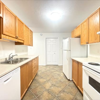 a kitchen with wooden cabinets and white appliances.