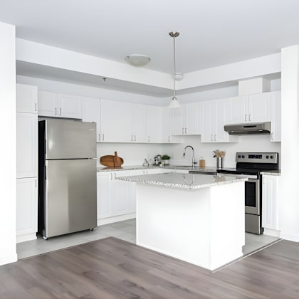 a modern kitchen with a stainless steel refrigerator and a white island.
